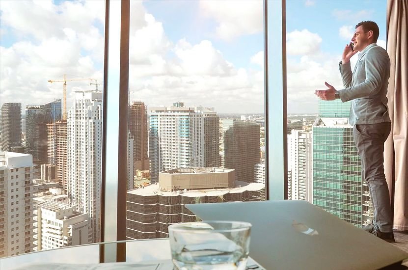 Man Standing in Office Building Window
